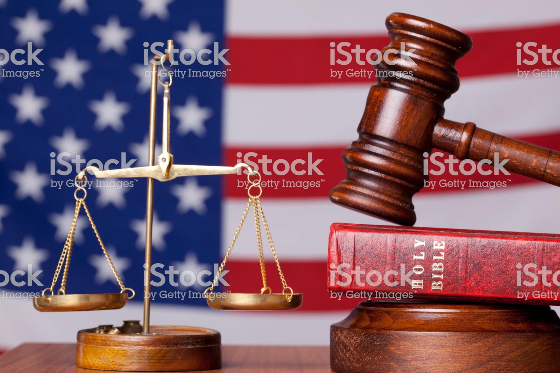 Photo of symbols of justice and Bible with American flag in the background